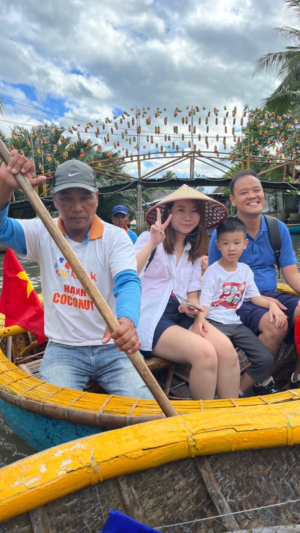 Tourists riding a coconut basket boat with a local rower in Hoi An