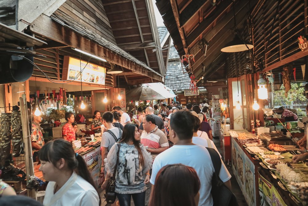 Visitors walking through busy food stalls at Pattaya Floating Market