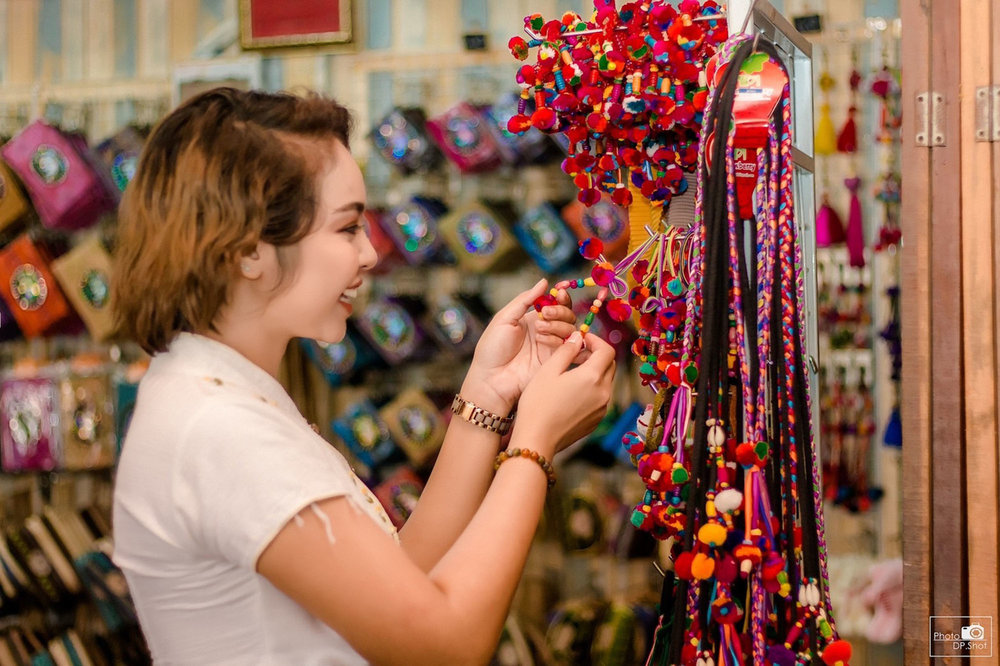 Woman browsing vibrant handmade accessories at Pattaya Floating Market