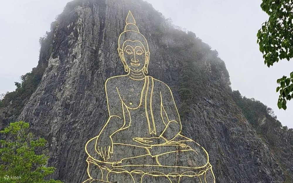 The massive Buddha etched on a tall limestone cliff at Khao Chi Chan