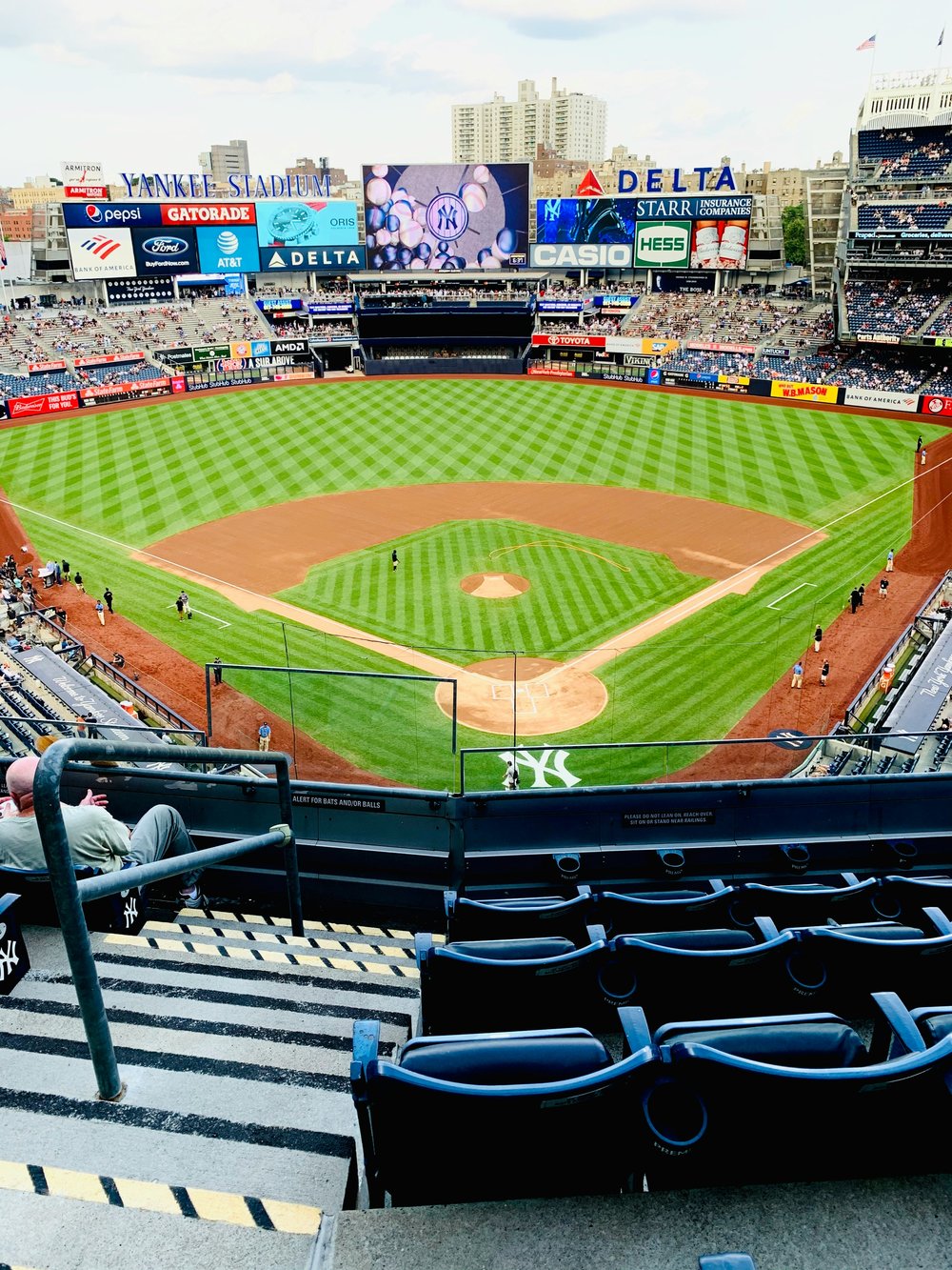 Green baseball field with seats from a distance