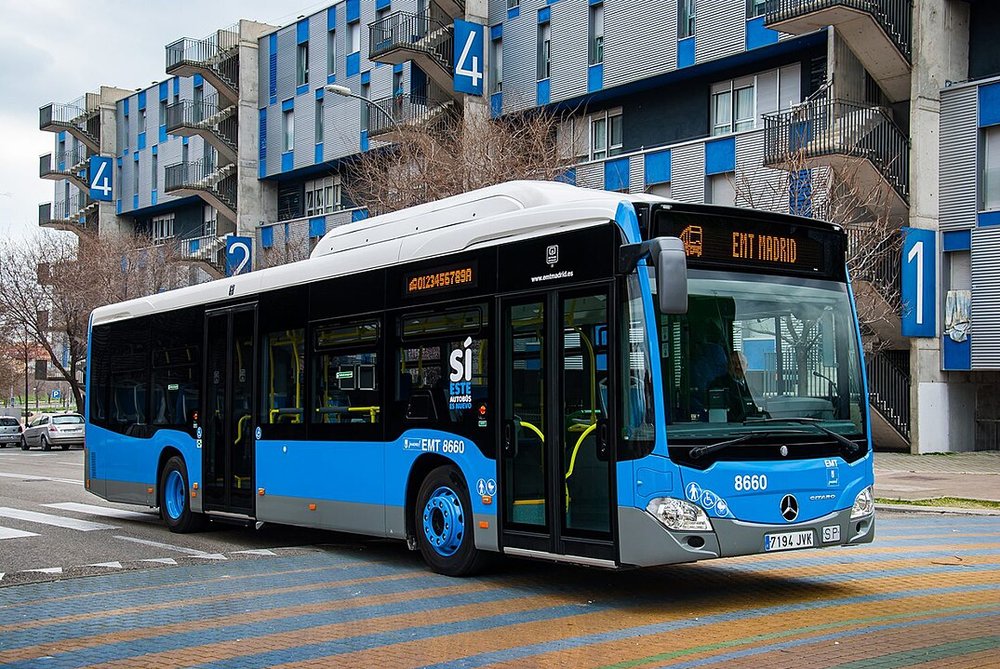 Blue bus in front of blue building