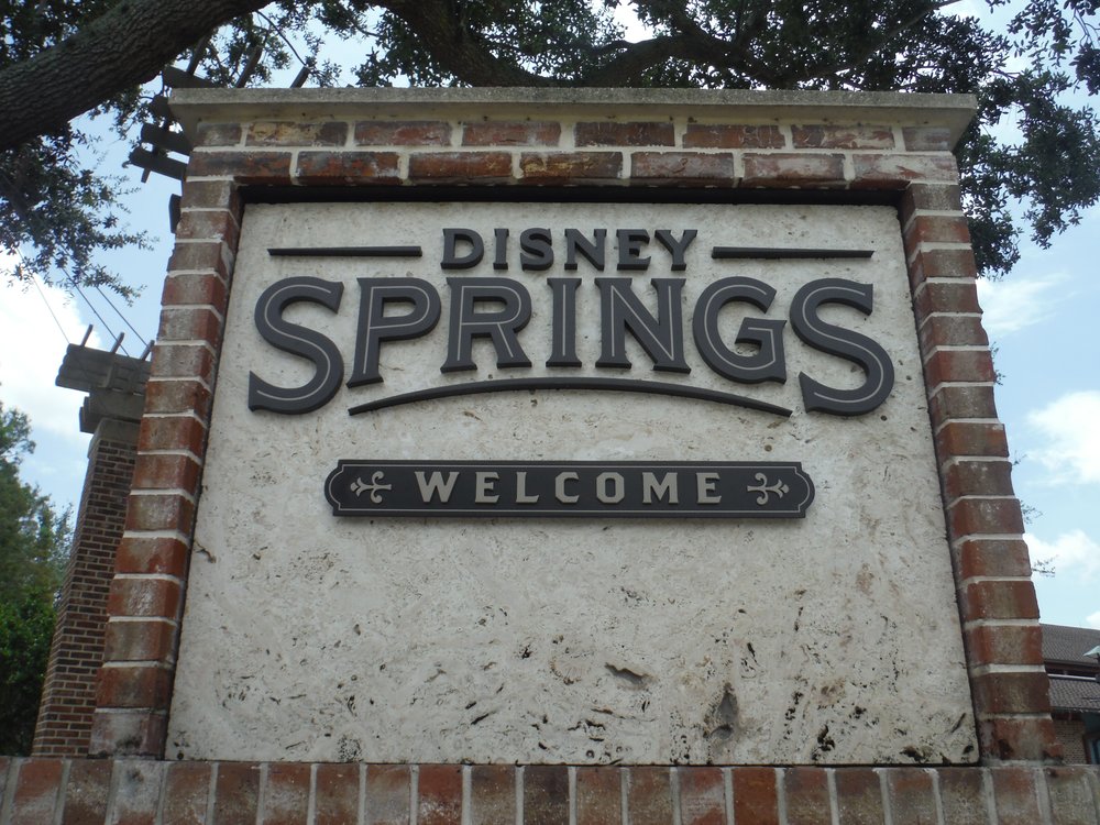 Brick and stone Disney Springs welcome sign at the district entrance