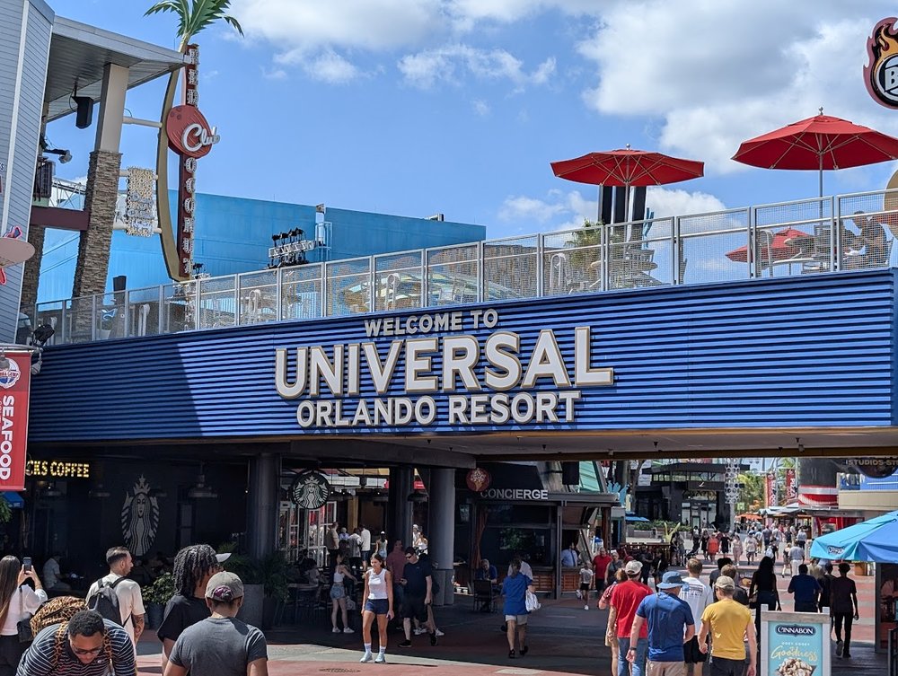 Crowds walking under the Universal Orlando Resort CityWalk entrance sign
