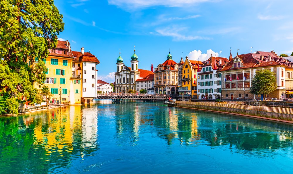 Bright Old Town Lucerne buildings reflected in the clear blue Reuss River