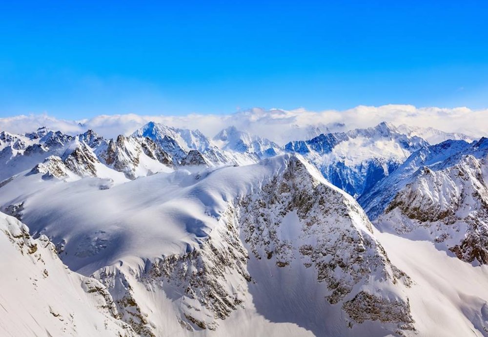 Panoramic snowy mountain peaks of Mount Titlis on a clear blue day