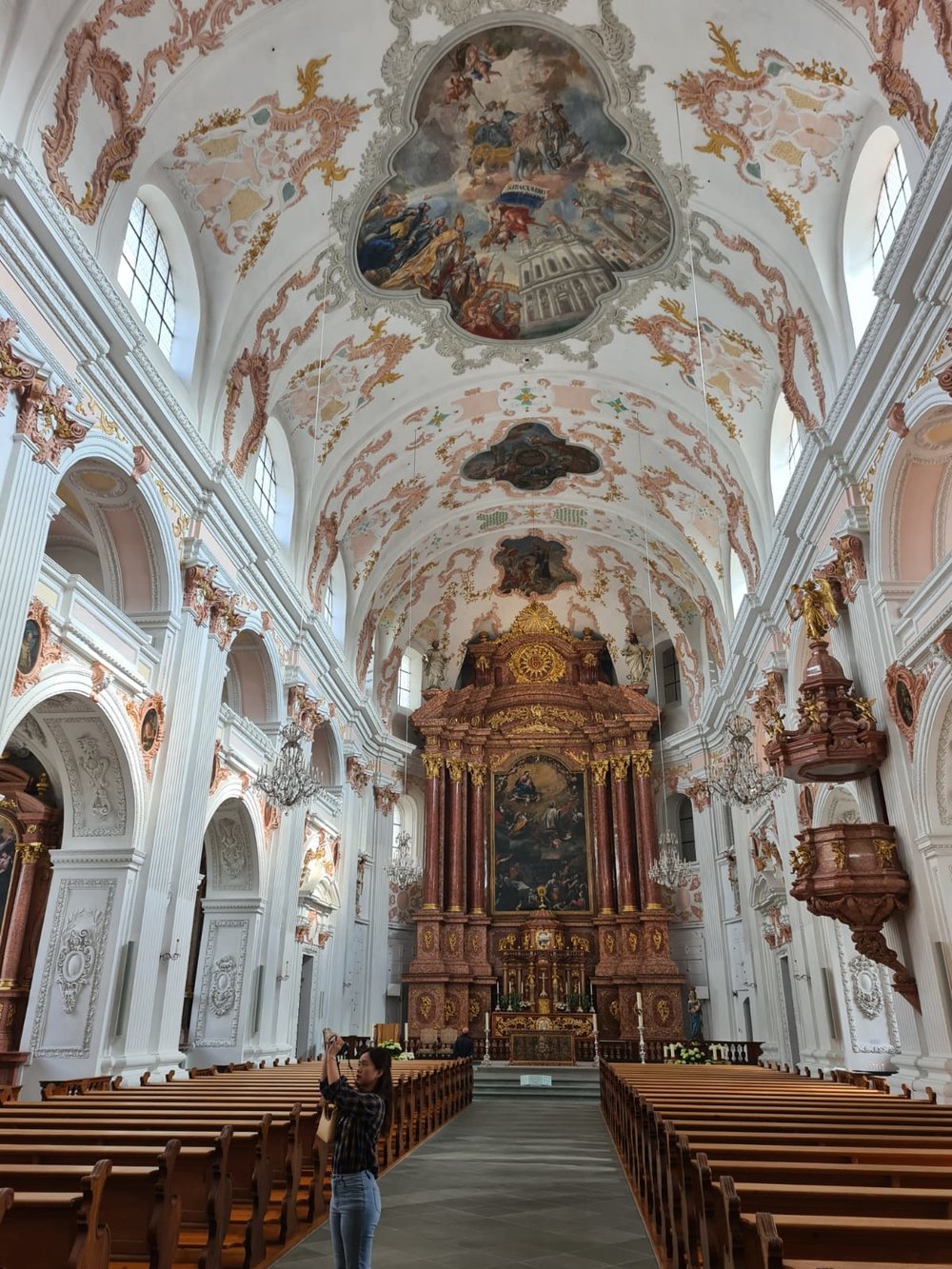 Ornate baroque church interior with painted ceilings and grand altar in Lucerne