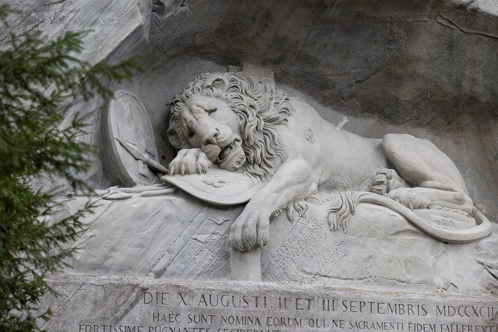 Detailed stone carving of the Lion Monument in Lucerne symbolizing Swiss bravery