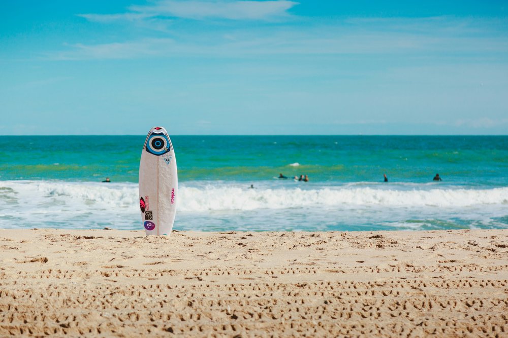 A surfboard on the shore of Sebastian Inlet.