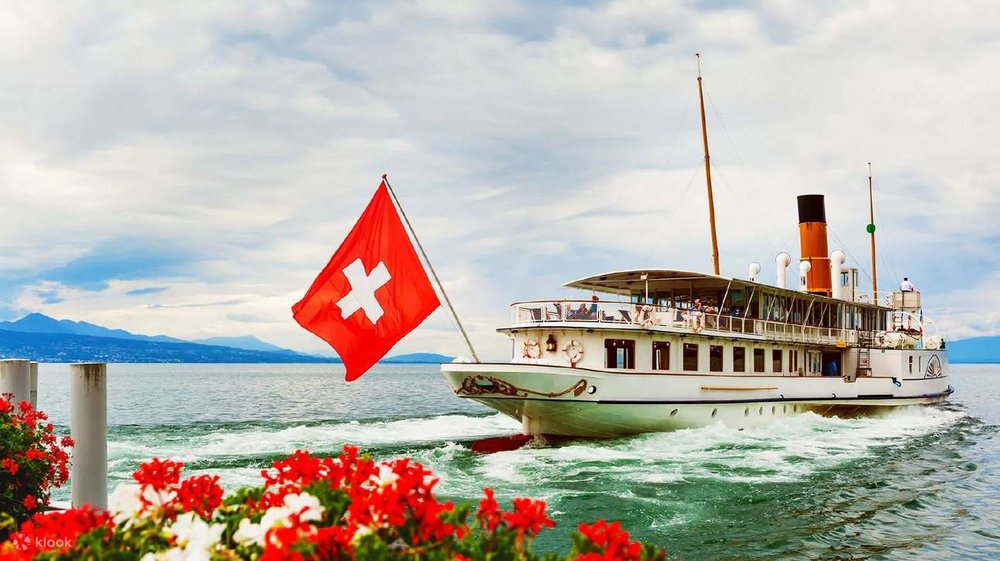 A ship, with a Swiss flag, cruising through Lake Geneva