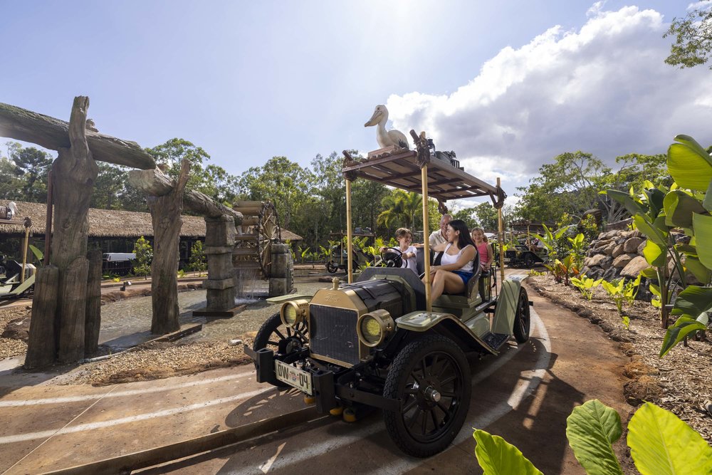 Guests riding Dreamworld’s vintage car attraction through themed scenery