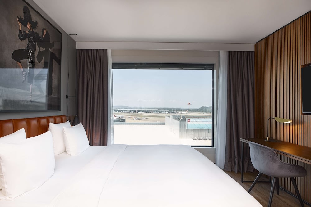 A hotel room with a window overlooking the airport runway