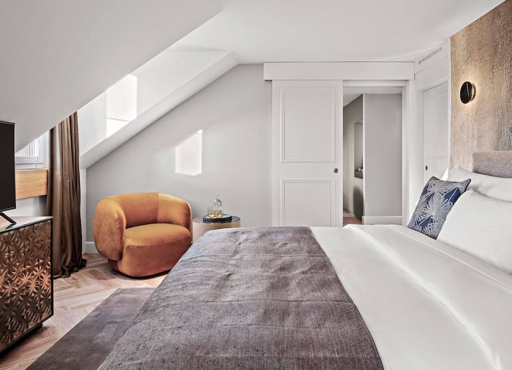 A spacious hotel room with a slanted ceiling