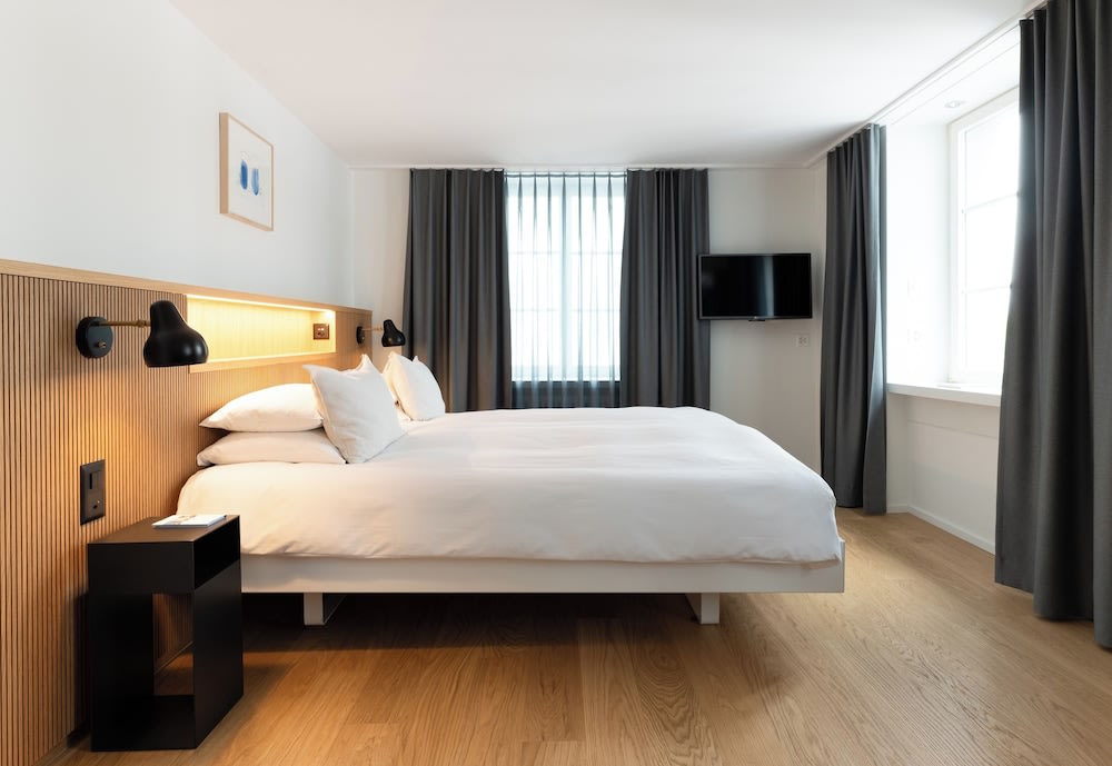 A bed facing a big window, while at its side is another big window