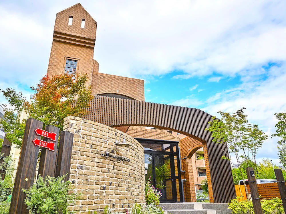 Exterior view of Riverside Arashiyama hotel with greenery and brick design