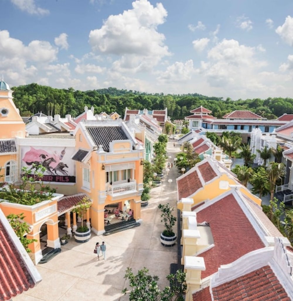 An aerial view of JW Marriott Phu Quoc Emerald Bay Resort & Spa.There are multiple buildings with French architecture as well as plants lining the buildings.