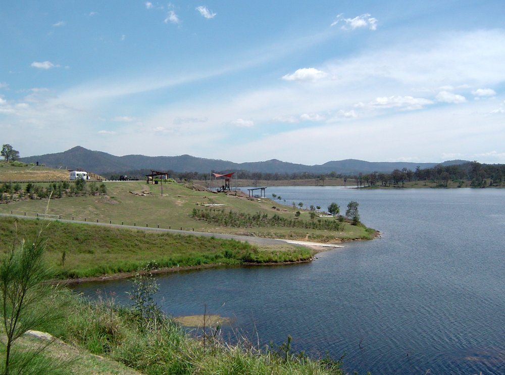 Scenic lakeside view of Lake Wyaralong with grassy picnic areas and hills