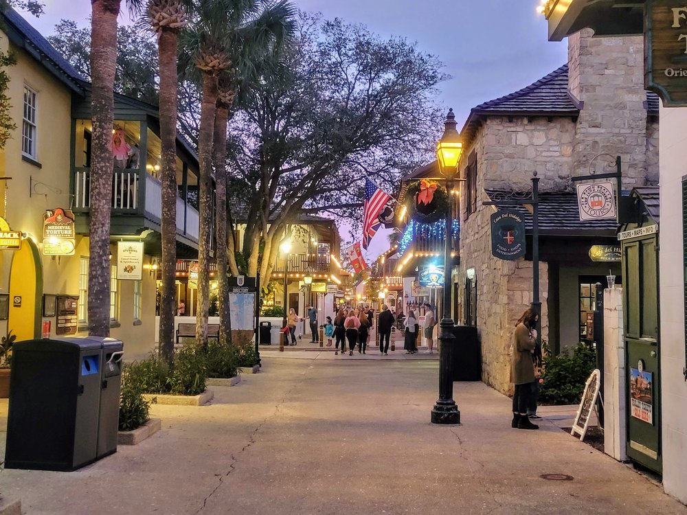People walking through St. Augustine’s historic St. George Street at dusk