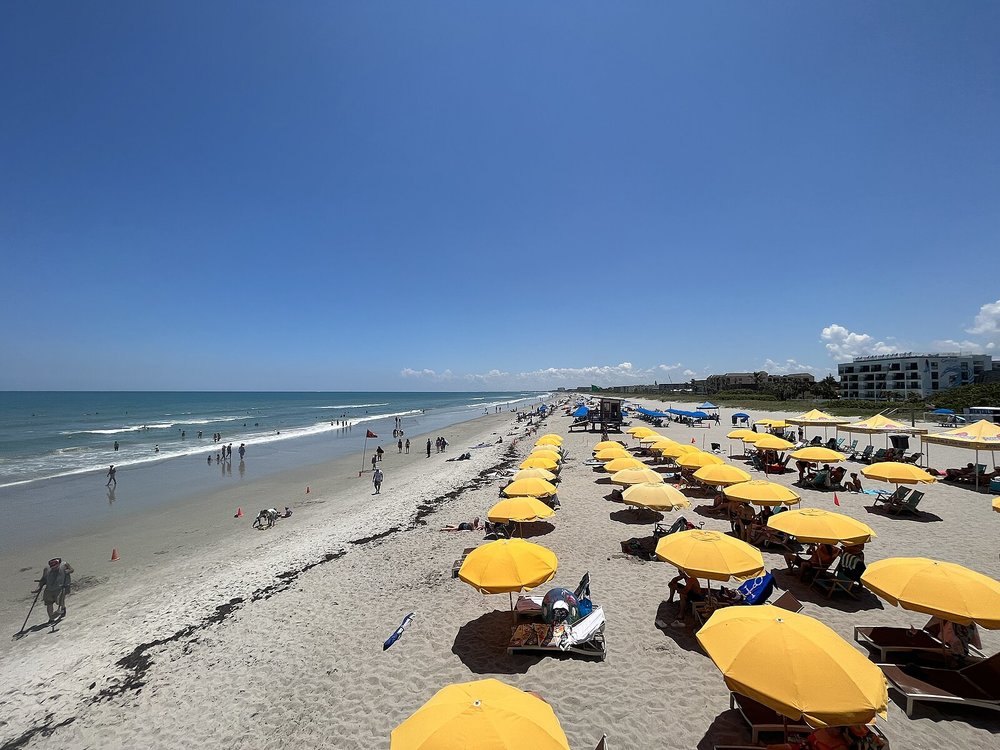 Cocoa Beach shoreline filled with yellow umbrellas and beachgoers