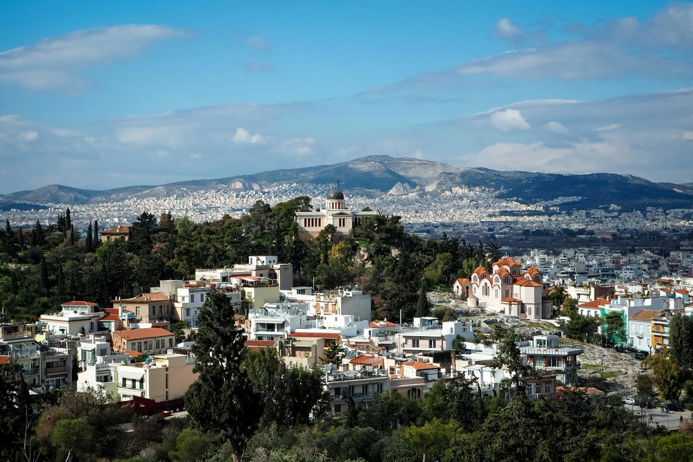 Athens cityscape with historic buildings and green hills