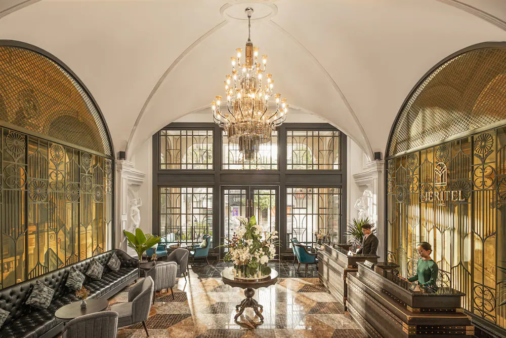 Meritel Hanoi hotel lobby with chandelier, seating area, and refined interior design