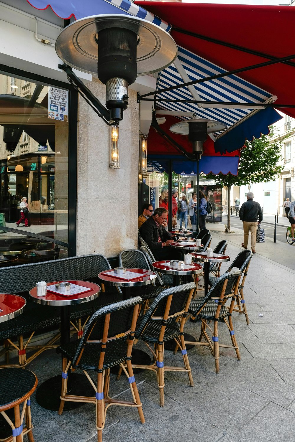 Outdoor café seating in Bordeaux with tables, chairs, and people dining