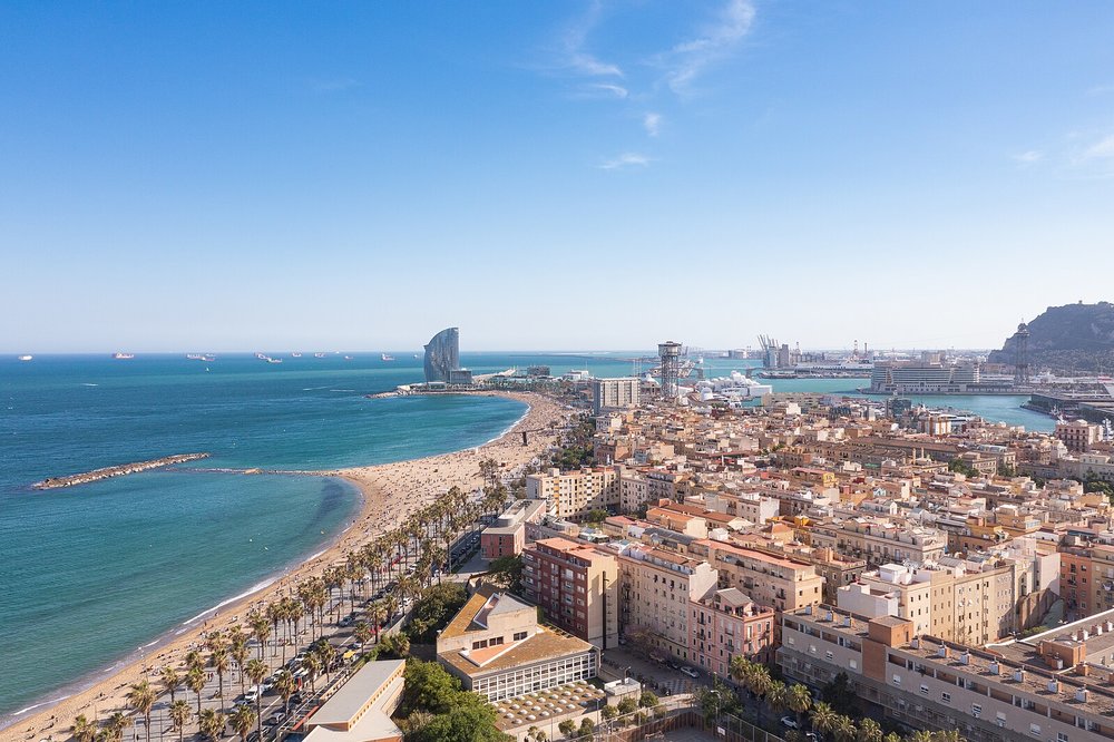 Aerial view of Barceloneta beach and Barcelona coastline on a sunny day