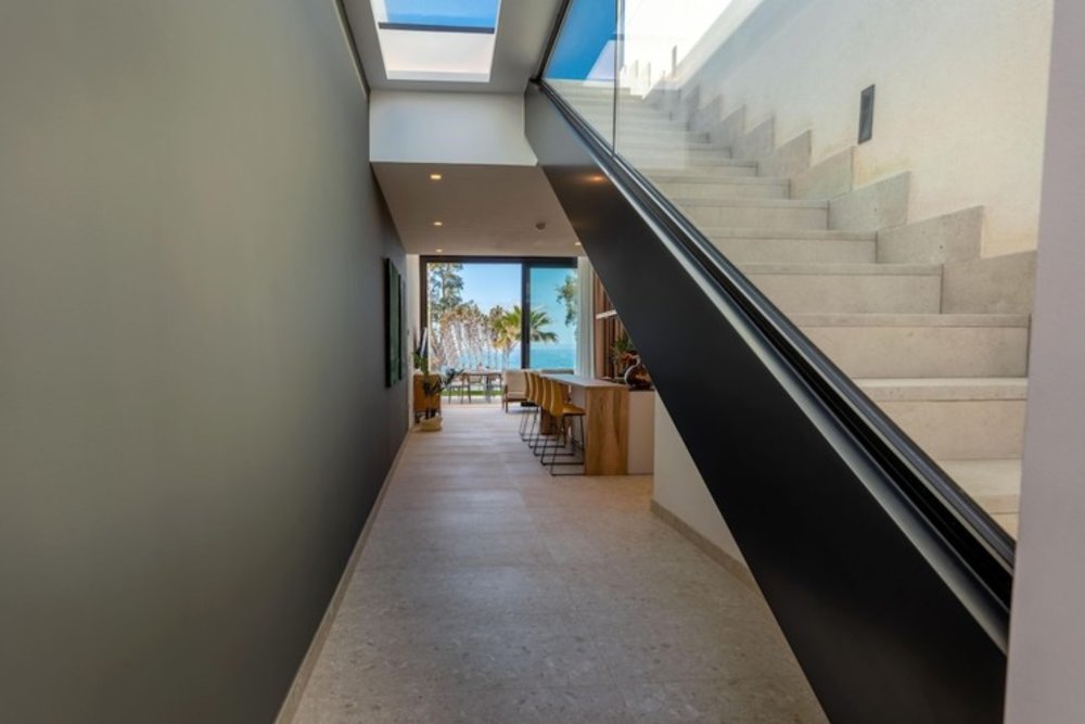 A hotel unit with a dining room and the beach is seen through the window