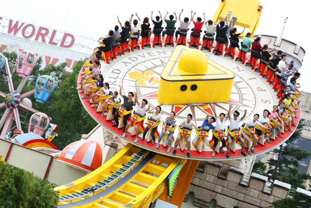Visitors enjoying a spinning thrill ride at Lotte World Seoul