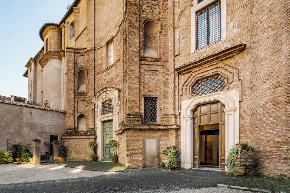 Stone courtyard and entrance of a historic hotel building in Trastevere, Rome