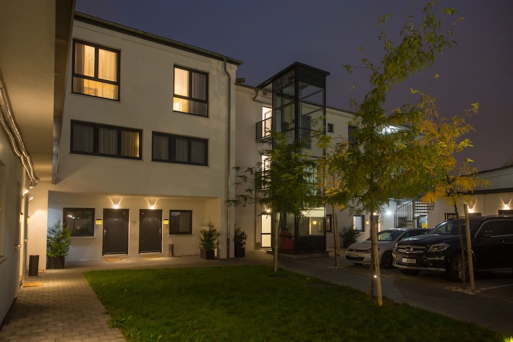 Modern hotel building in Rome with courtyard and parking area at night