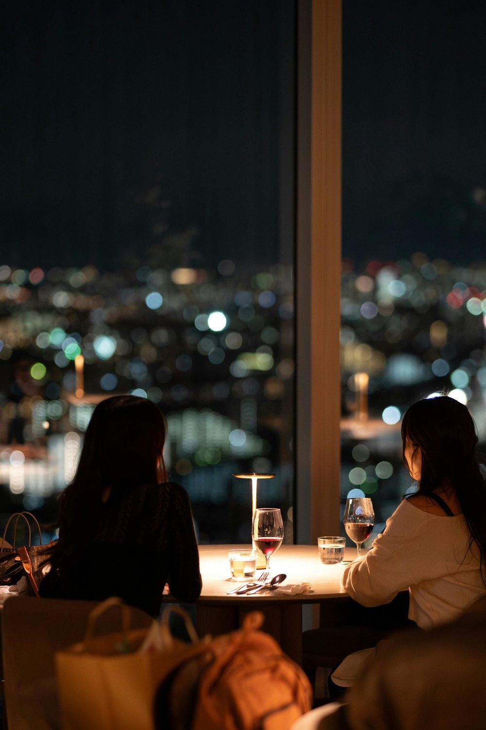 People enjoying drinks at a rooftop bar in the UK overlooking the city at night