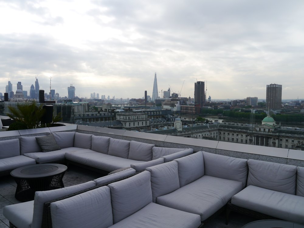 Outdoor seating at a rooftop bar in London overlooking the city skyline 