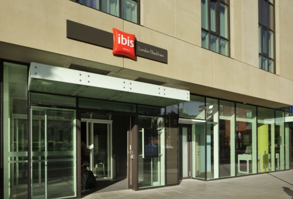Entrance of Ibis London Blackfriars hotel with glass facade in London