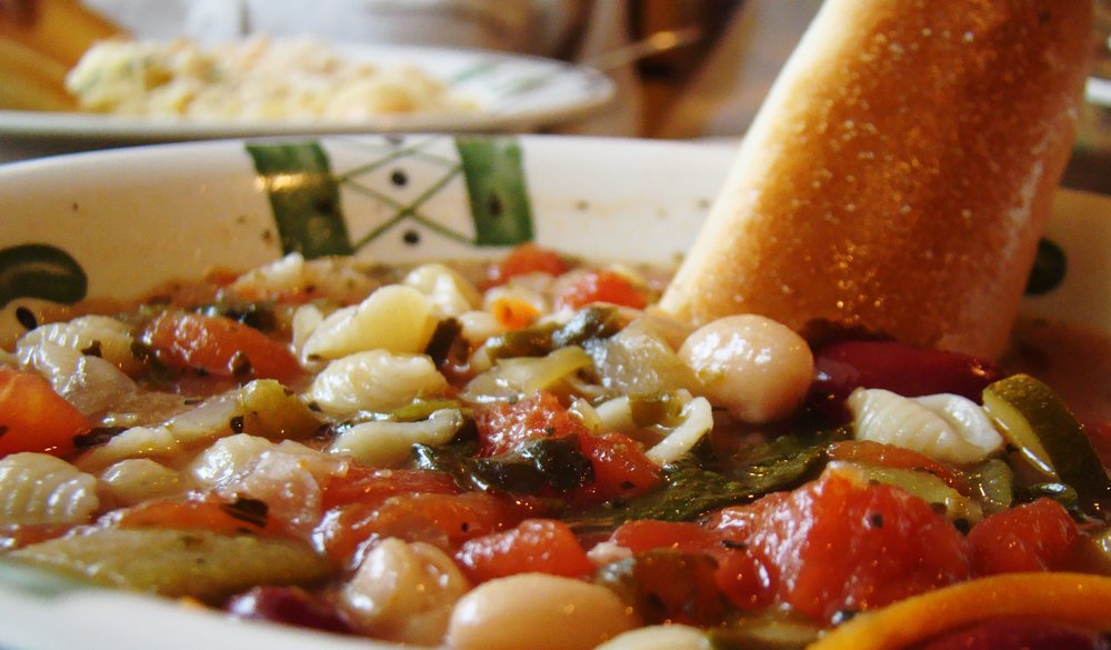 Bread dipped in minestrone soup