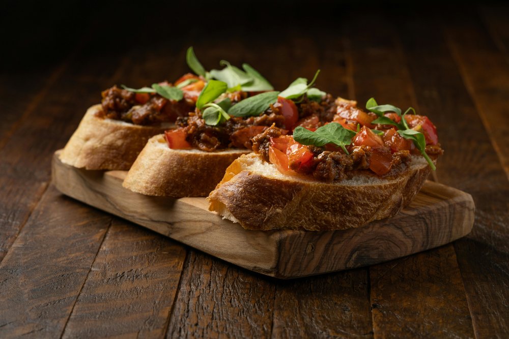 Three pieces of bruschetta on a wooden board