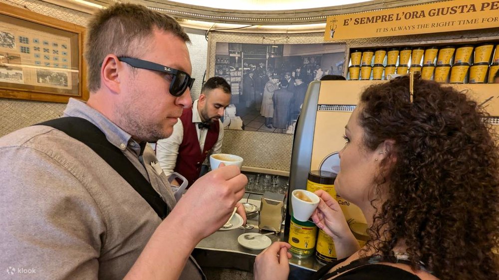 A man and woman sipping on a cup of espresso each