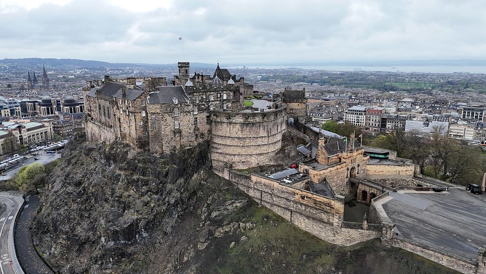 Aerial view of Edinburgh Castle sitting on a rocky hill above the city