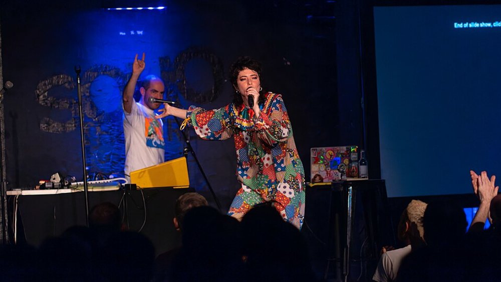 Performer on stage at an intimate London theater with live audience