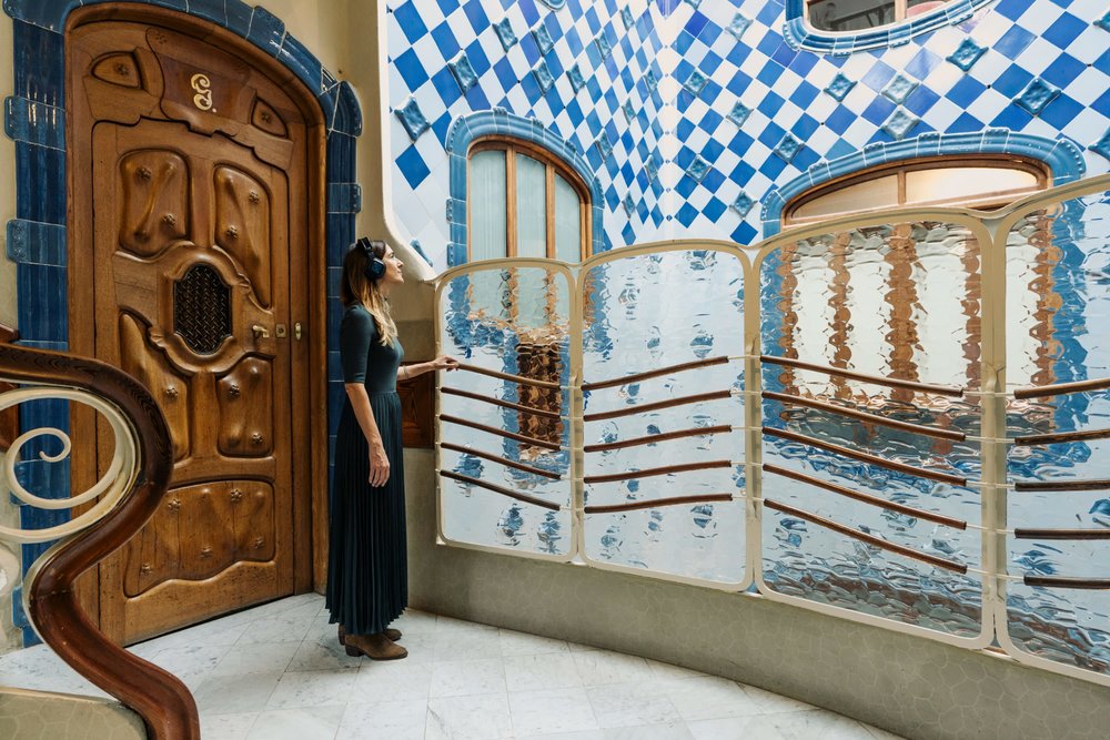 A tourist listening to an audio guide while exploring Casa Batllo