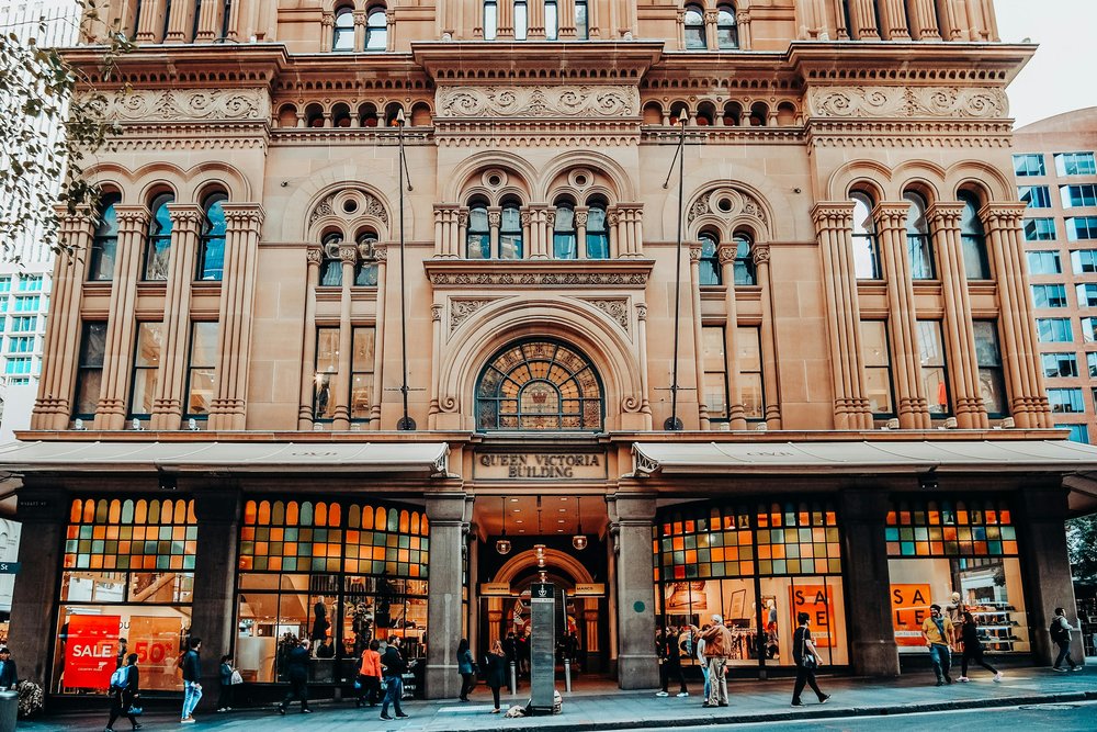 Exterior of the Queen Victoria Building in Sydney with shoppers walking past