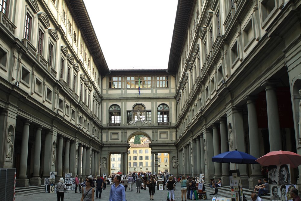 Uffizi Gallery courtyard in Florence with visitors walking between historic buildings