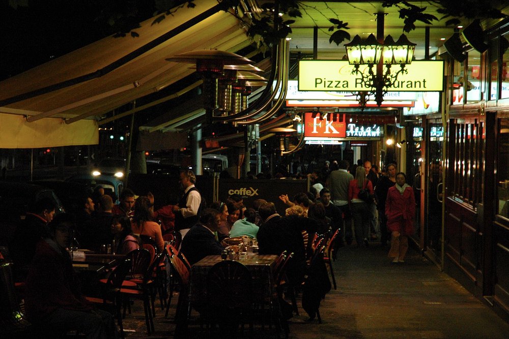 Nighttime dining along Lygon Street with Italian restaurants