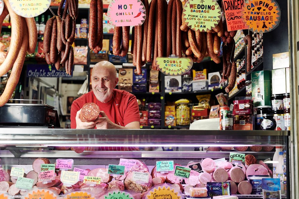 Vendor stall at Queen Victoria Market with cured meats and local produce