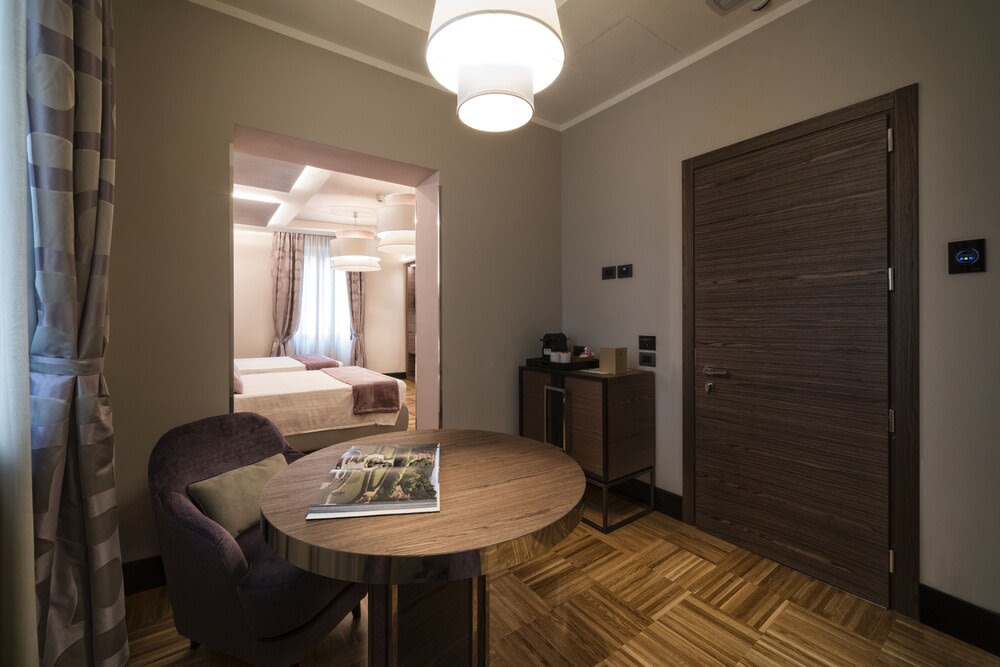 A small foyer inside the hotel room, with a wall separating it from the beds