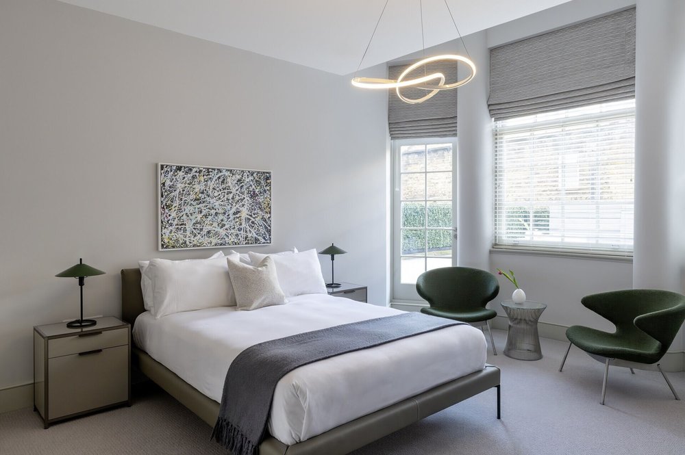 Modern bedroom at AKA Marylebone with seating area and natural light