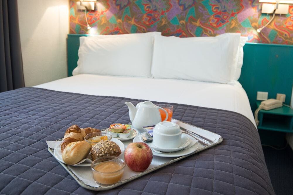 Hotel room with breakfast tray on bed and colorful headboard