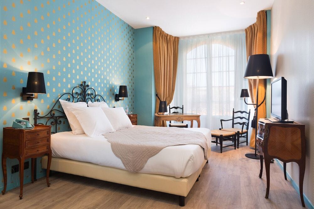  Bright hotel room with patterned wall, double bed, and classic decor
