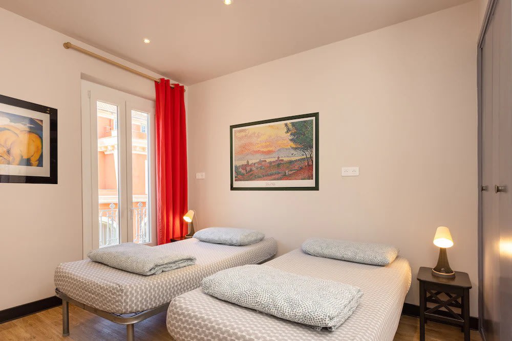  Twin hostel room with single beds and red curtains