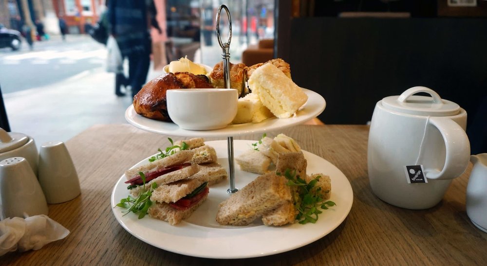 A selection of pastries and finger sandwiches along with loose leaf or flowering teas
